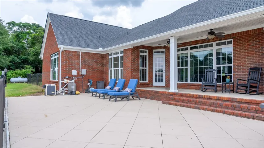 A spacious brick patio provides ample room for outdoor enjoyment and poolside lounging.