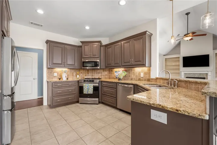 A well-appointed kitchen features ample cabinetry, granite countertops, and modern stainless steel appliances.