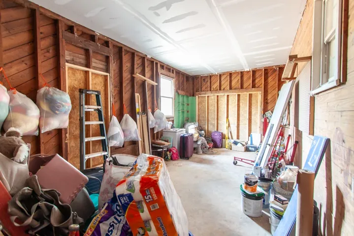 A versatile storage room, ready for transformation, boasts exposed wood walls and ample room.