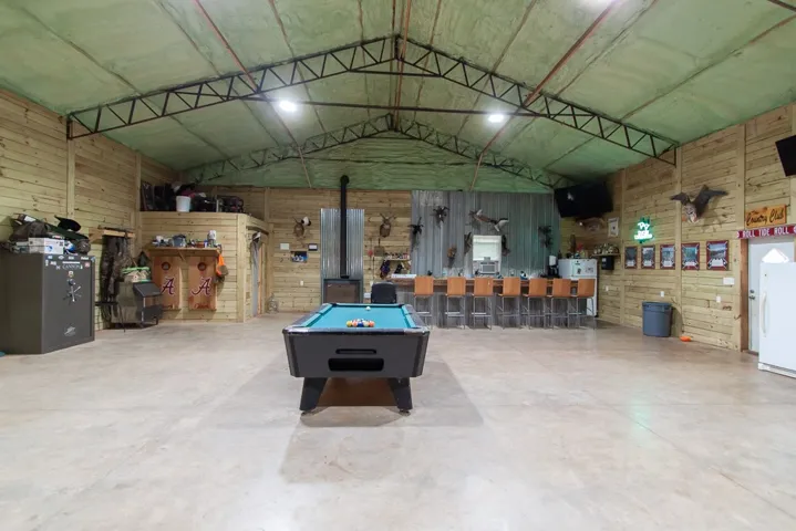 Vast recreation room with an exposed beam ceiling offers ample space for entertainment.