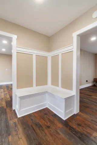 Built-in corner bench seating with crisp white wainscoting provides a welcoming touch in this inviting entry.