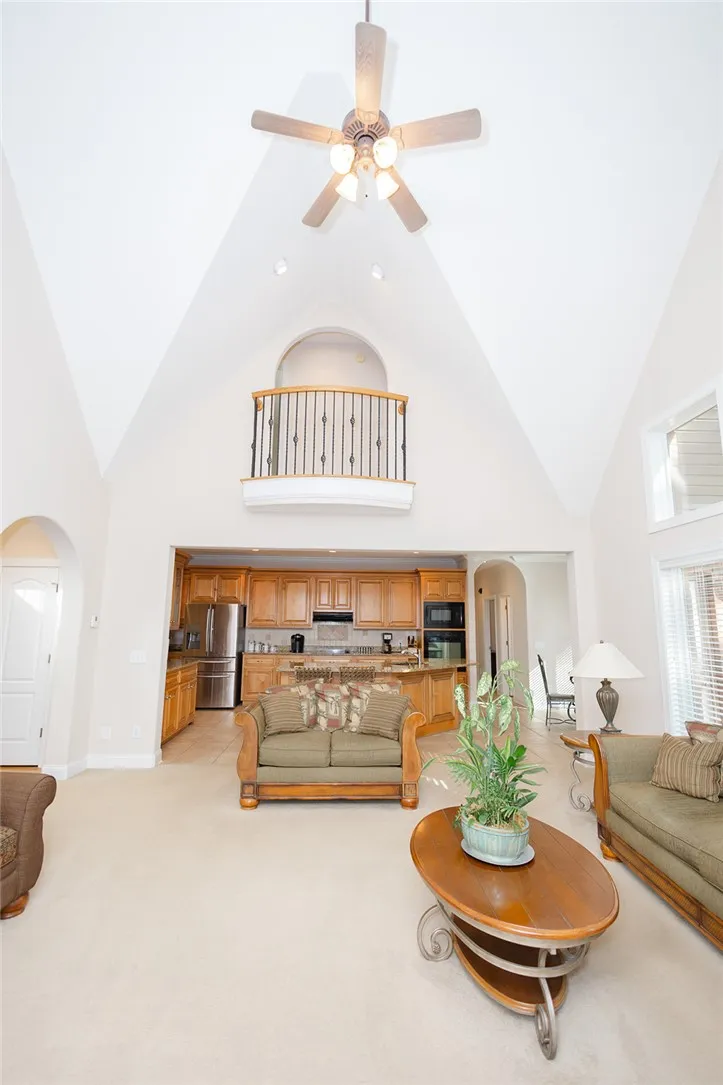 A grand living area boasts soaring vaulted ceilings and an elevated interior balcony.