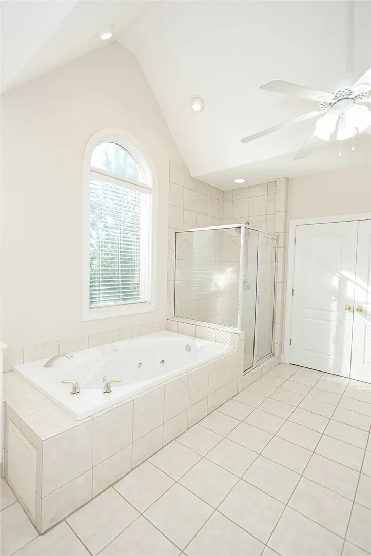 Indulge in a primary bathroom featuring a spacious jetted tub and a walk-in shower.