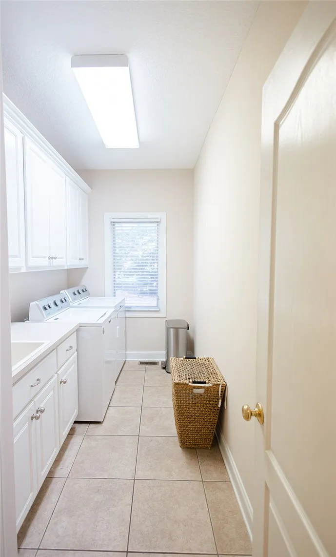 A well-appointed utility room features a washer, dryer, and ample storage cabinets for household convenience.