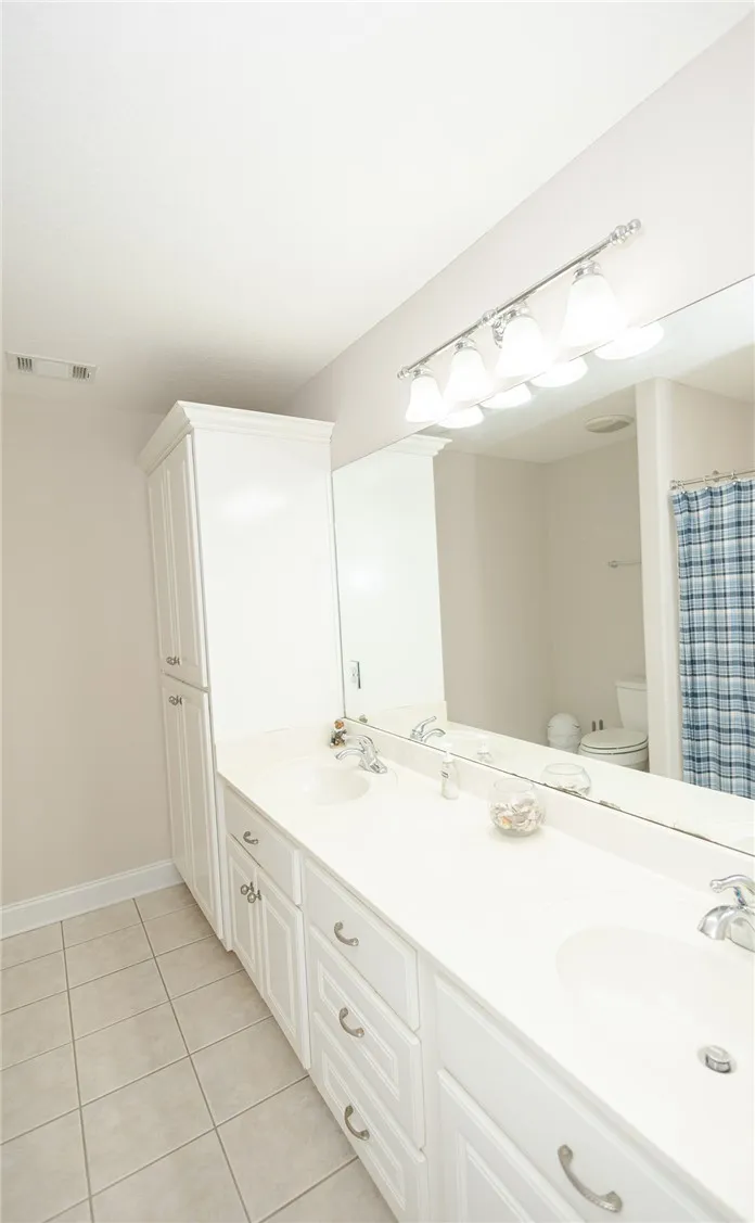 Dual vanities with pristine counters elevate this well-appointed bath.