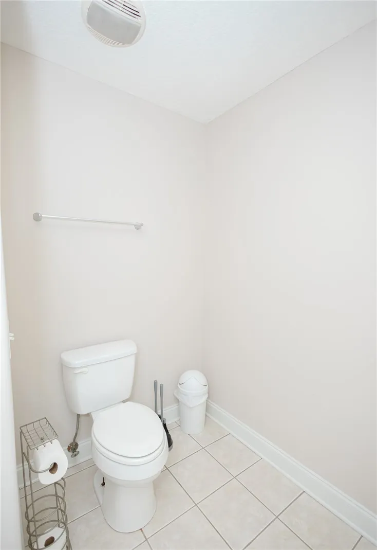 A well-maintained bathroom with a toilet and tile flooring provides functional simplicity.