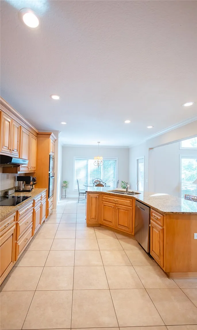 A well-appointed kitchen showcasing light wood cabinetry and resilient tiled flooring.