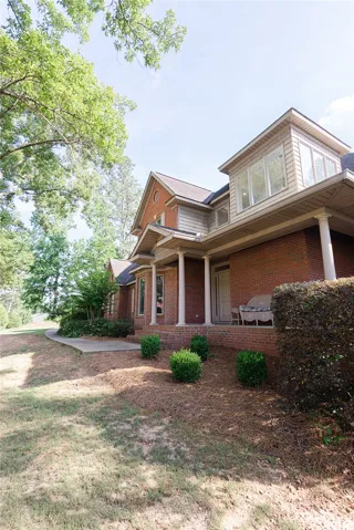 A classic brick facade with a welcoming covered porch sets a distinguished tone.