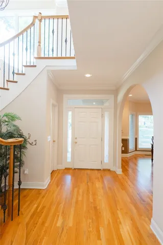A grand entrance with gleaming hardwood floors and an elegant staircase sets a welcoming tone.