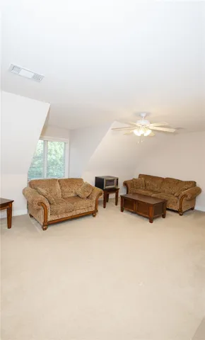 A well-lit bonus room provides a versatile living space with sloped ceilings.