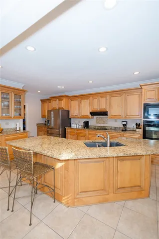 A grand central island anchors this spacious kitchen, boasting abundant cabinetry and recessed lighting.