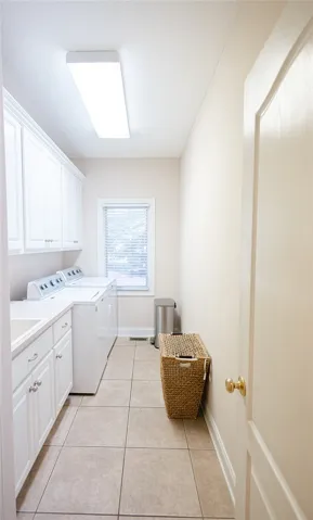 A well-appointed utility room features a washer, dryer, and ample storage cabinets for household convenience.
