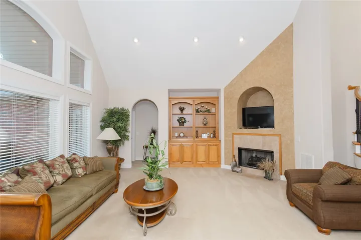 A spacious living area features high vaulted ceilings and a warm, inviting fireplace.