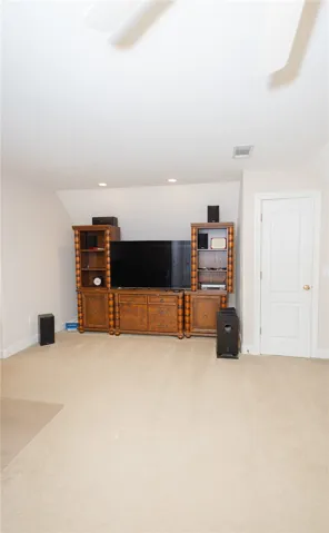 A versatile bonus room or entertainment area, perfect for a variety of uses, featuring plush carpeting.