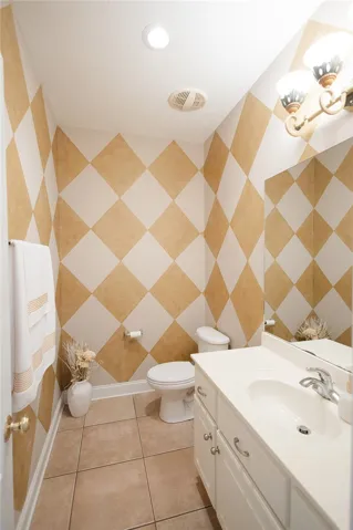 Bold diamond-patterned walls and tile flooring define this compact, well-appointed lavatory.
