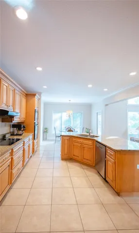 A well-appointed kitchen showcasing light wood cabinetry and resilient tiled flooring.