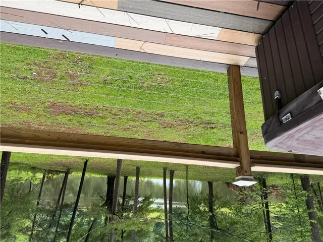 An inviting deck offers a relaxing spa and expansive views of the adjacent lake.