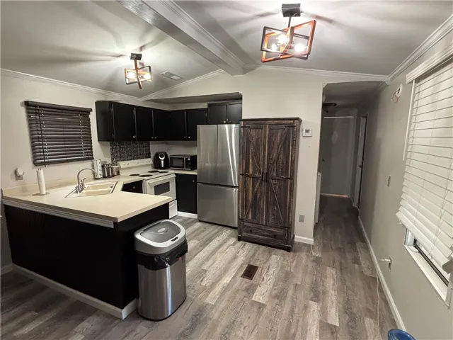 A streamlined kitchen layout offers essential appliances and durable flooring for daily living.
