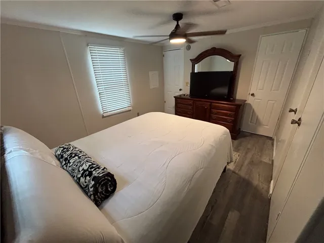 Well-lit sleeping quarters with rich wood-tone flooring offers comfortable relaxation.
