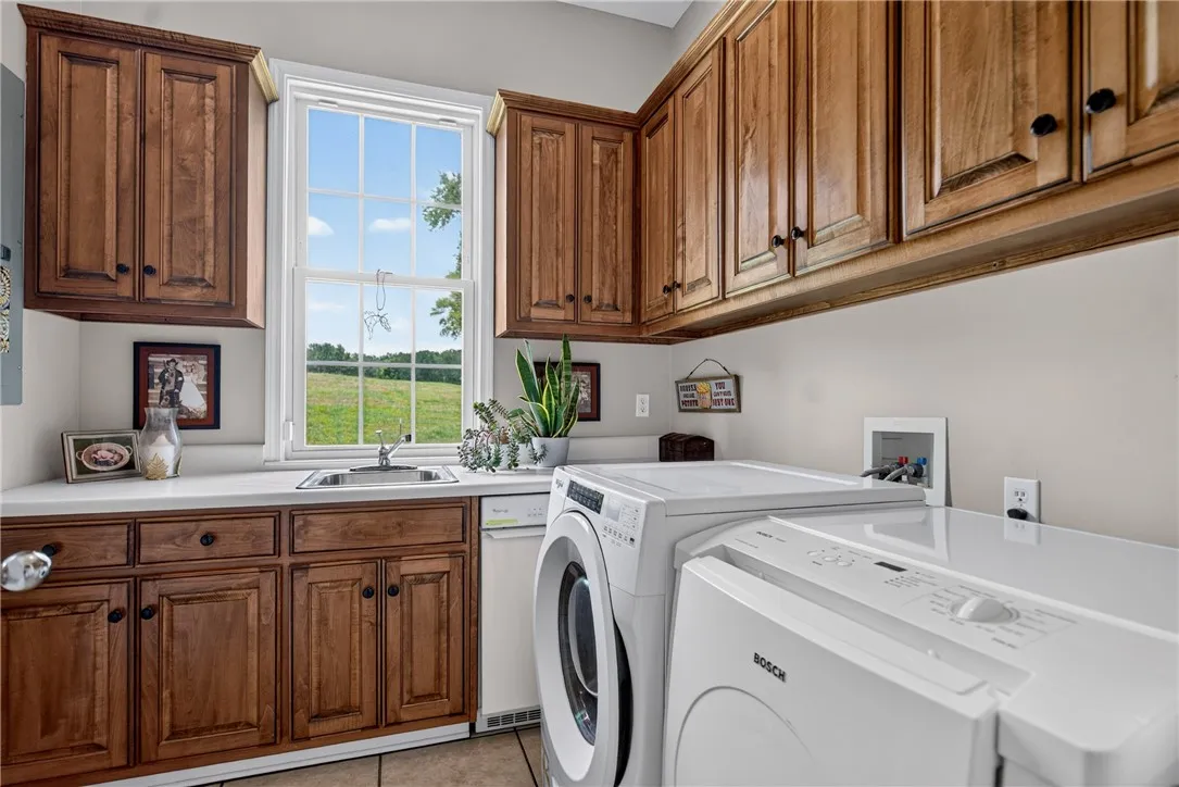 Functional laundry room offers a generous window view and ample cabinetry.