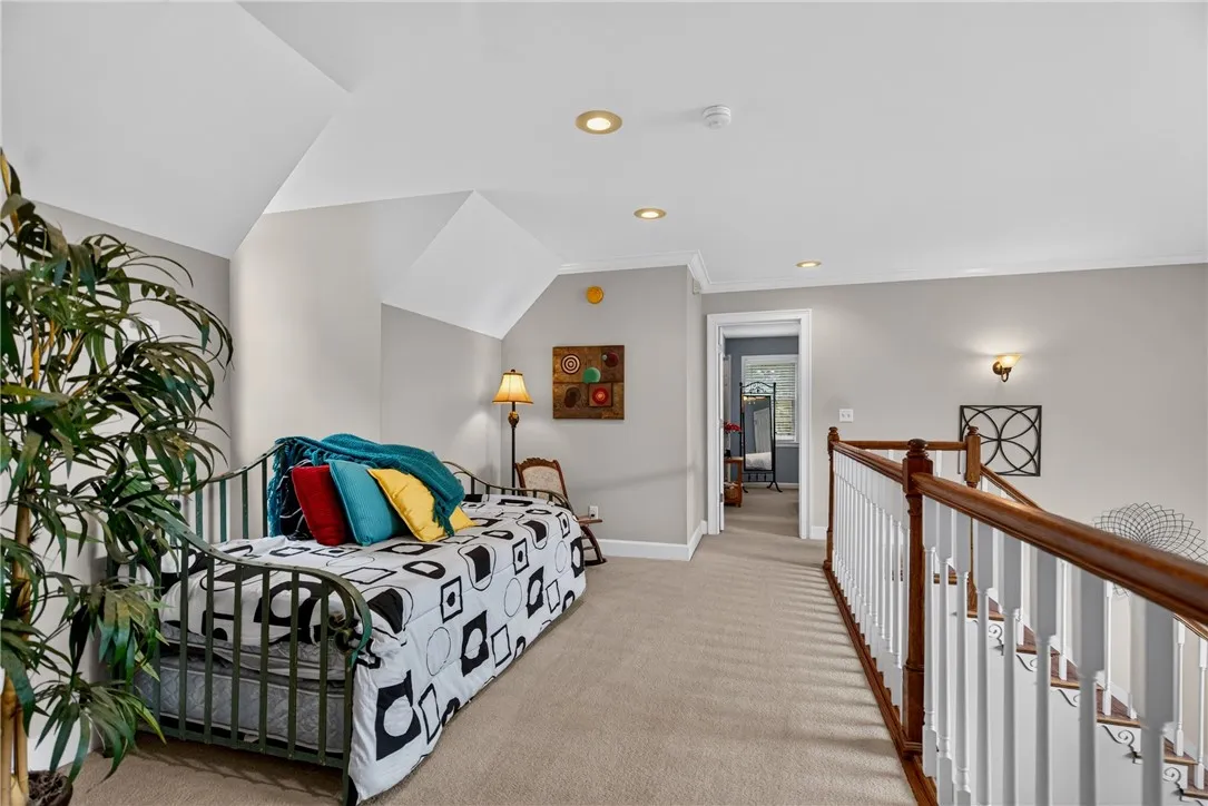 A versatile loft space featuring a cozy daybed and inviting carpeted floors.