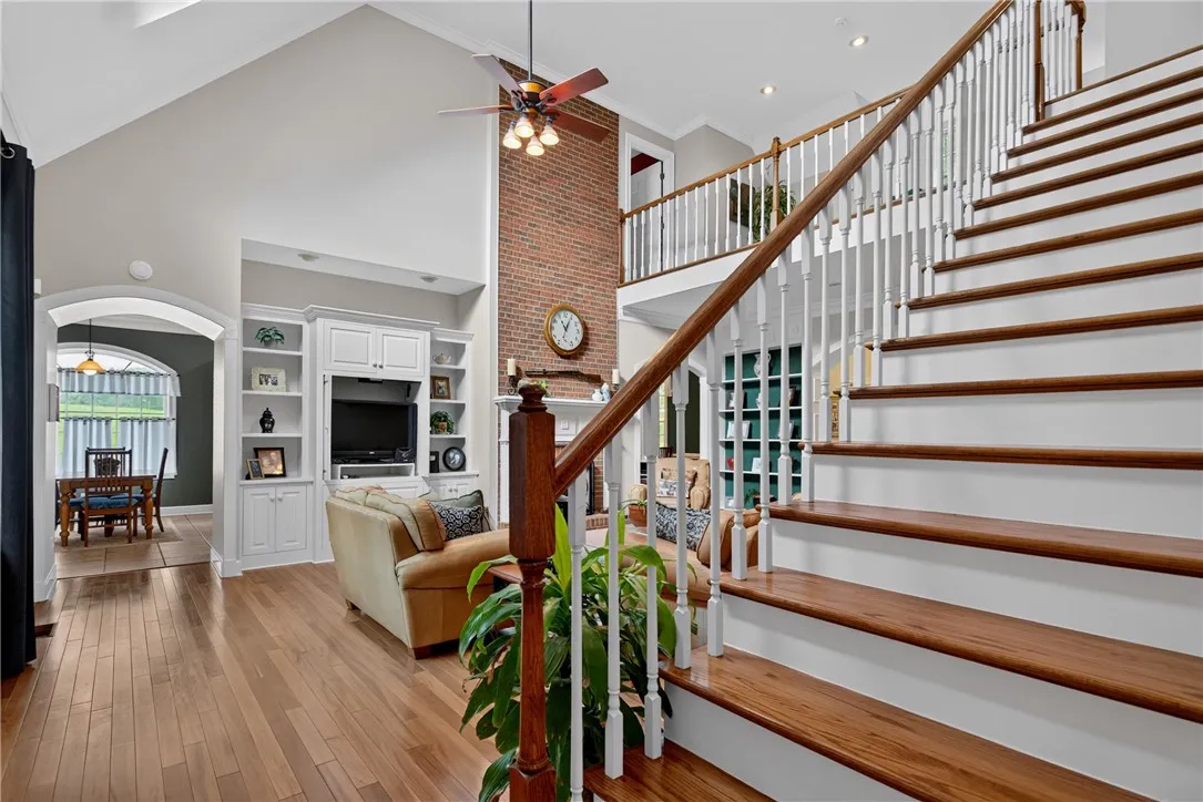 Grand two-story living area with gleaming hardwood floors and an elegant staircase.