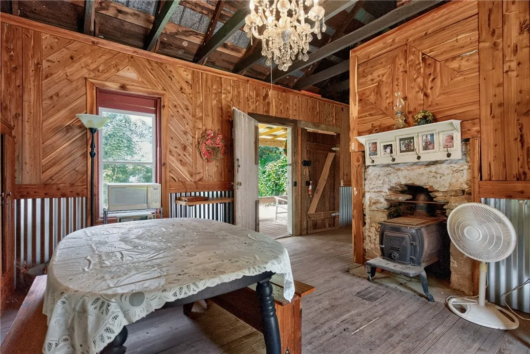 A rustic interior with exposed wooden beams and a classic wood-burning stove offers countryside charm.