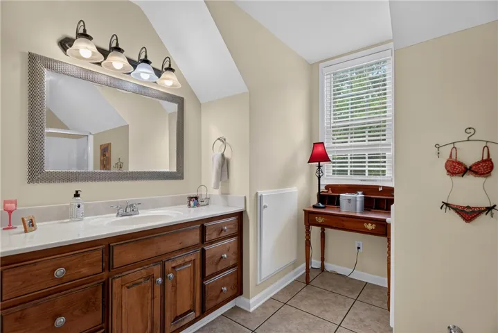 Well-lit vanity with a broad mirror, offering a perfect spot for morning routines.