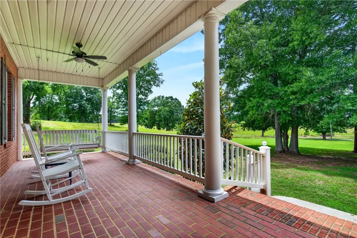 Relax on the spacious brick porch with verdant views of the surrounding grounds.