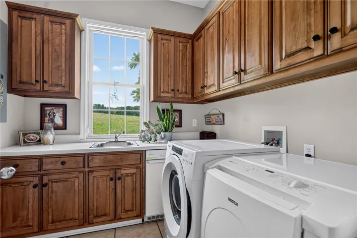 Functional laundry room offers a generous window view and ample cabinetry.