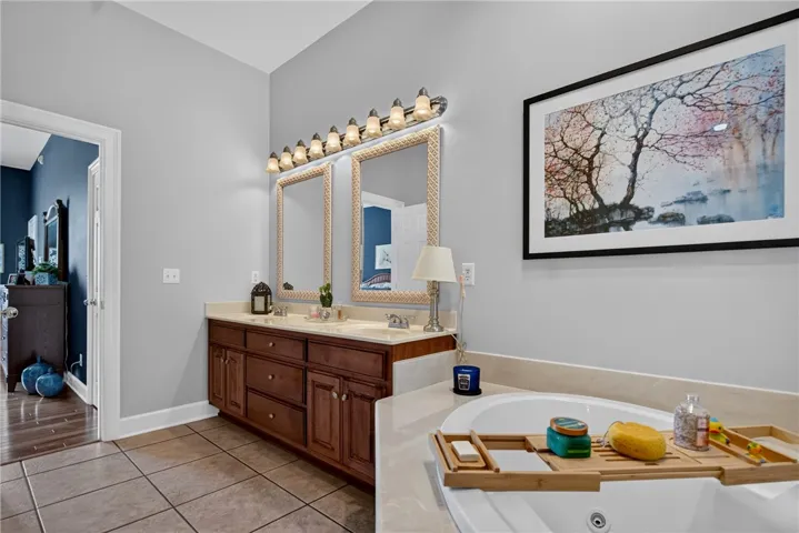 Luxurious bathing quarters feature a deep soaking tub alongside a double vanity, providing abundant room for personal care.