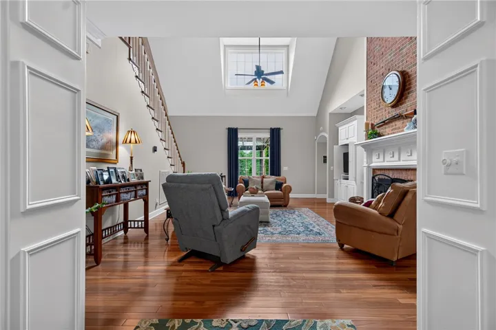 Hardwood floors and a towering brick fireplace create a welcoming, open atmosphere.