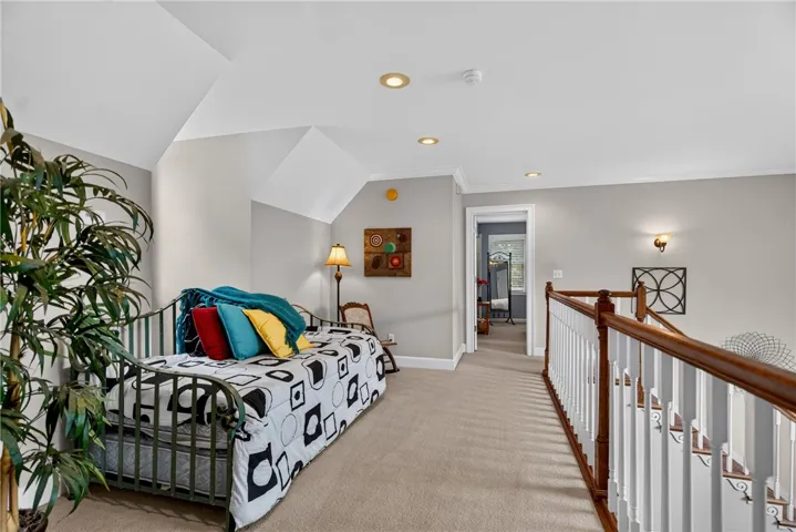 A versatile loft space featuring a cozy daybed and inviting carpeted floors.