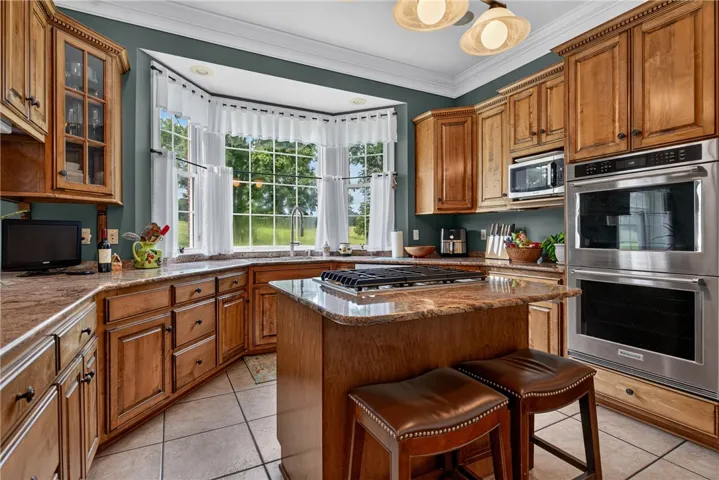 A chef's kitchen features stainless steel appliances and a spacious island with a gas cooktop.