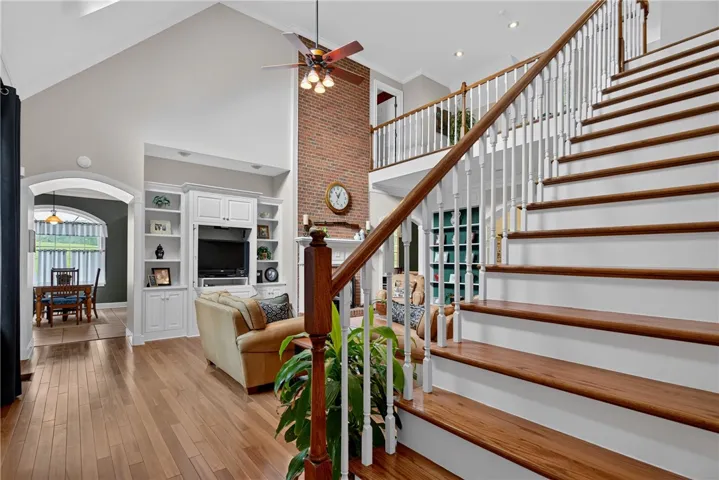 Grand two-story living area with gleaming hardwood floors and an elegant staircase.