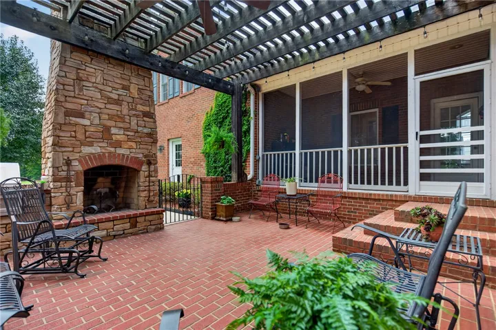 An inviting brick patio with an outdoor stone fireplace awaits, perfect for gatherings.