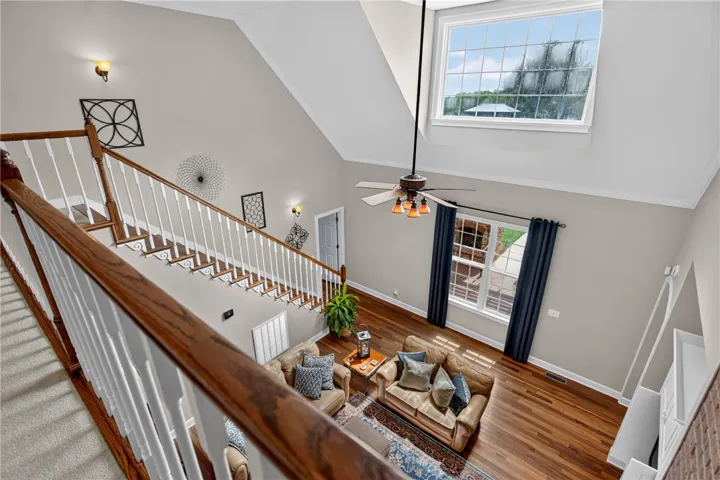 A grand, naturally illuminated living area with high ceilings and rich hardwood flooring, perfect for gatherings.