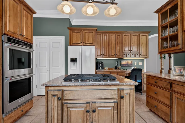 A warm, inviting kitchen presents ample cabinetry and a practical central island with a cooktop.