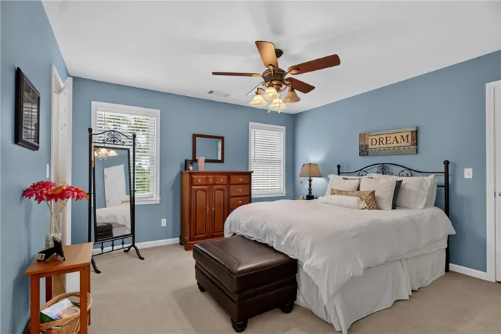 A well-lit room with soft blue walls, inviting restful slumber, and adorned with tasteful furniture.