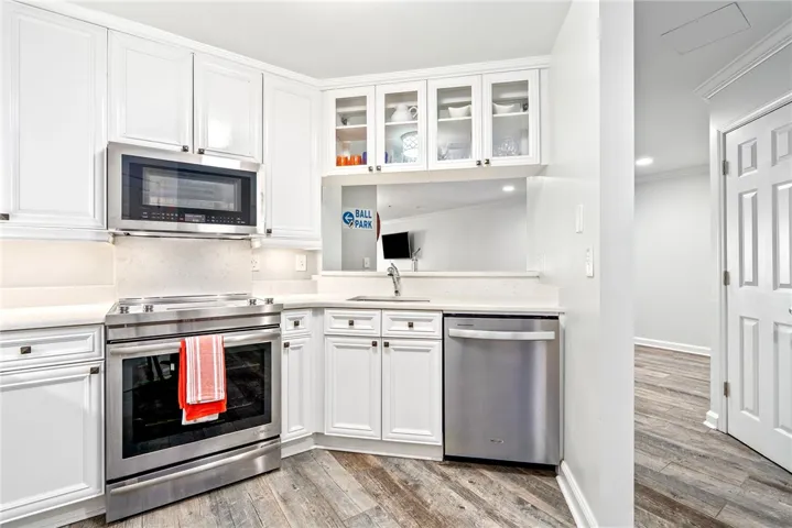 A well-lit kitchen with sleek stainless steel appliances and ample cabinetry.