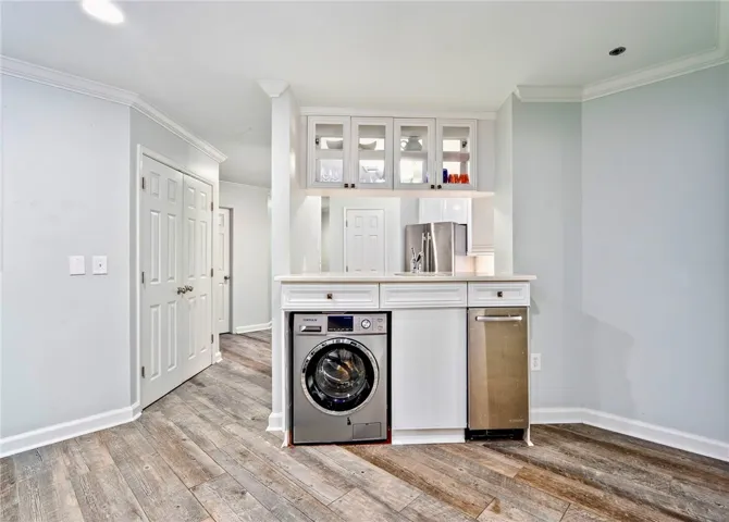Functional utility space with modern appliances and durable wood flooring.