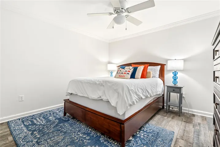 Restful bedroom featuring crown molding and resilient flooring.