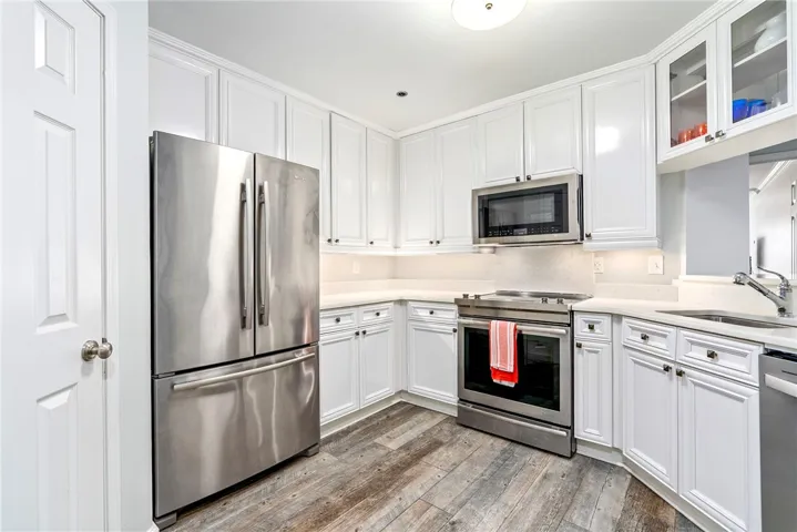 A pristine kitchen offers sleek stainless steel appliances, abundant cabinetry, and durable flooring.