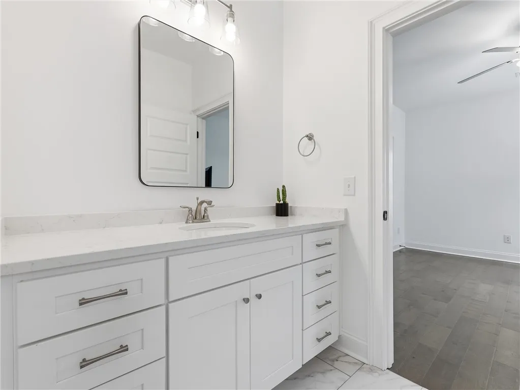 White cabinetry with ample storage and a quartz countertop make this bathroom vanity functional and beautiful.