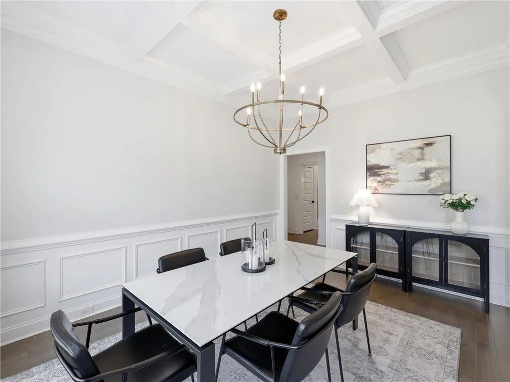 A formal dining area showcasing intricate ceiling millwork and polished hardwood flooring.