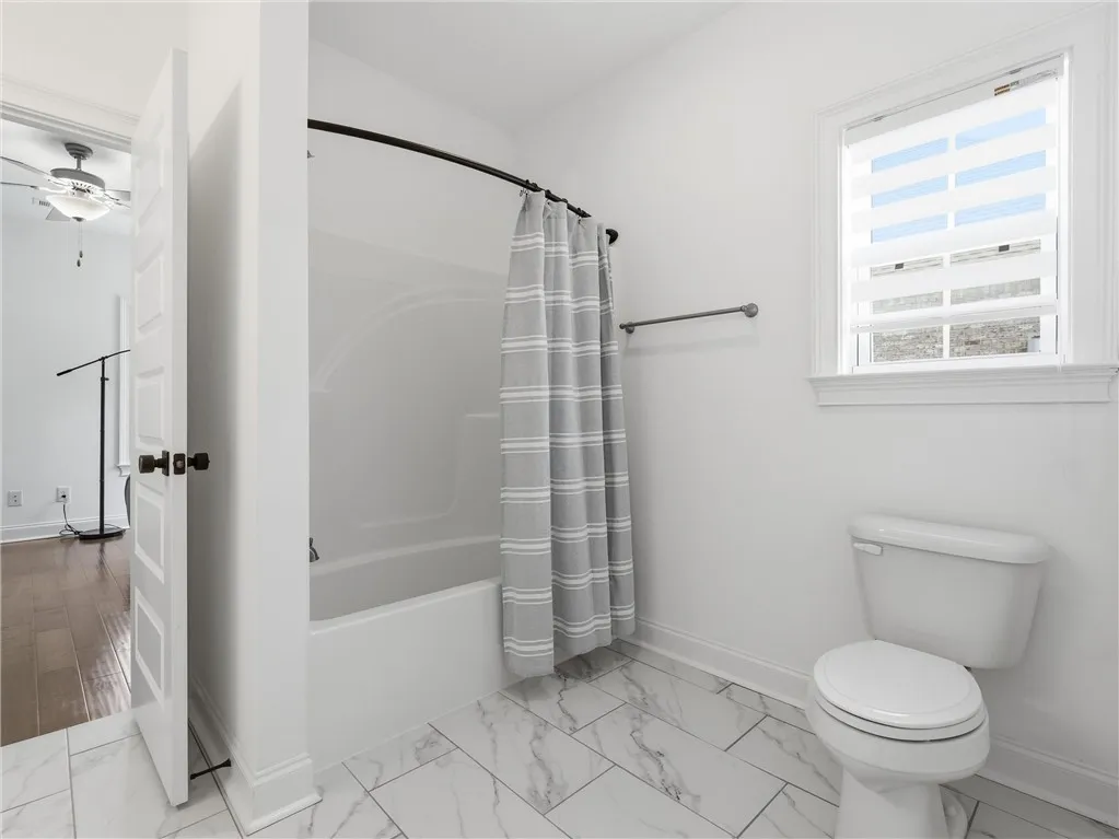White ceramic tile flooring complements the bright bath area with a clean, functional aesthetic.