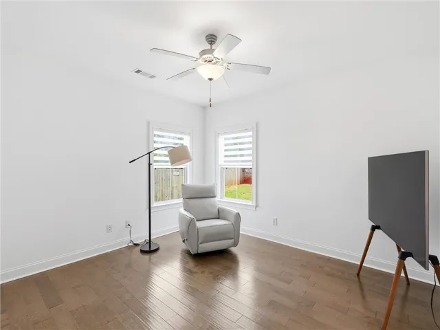 Hardwood floors and bright windows illuminate this cozy and adaptable room.
