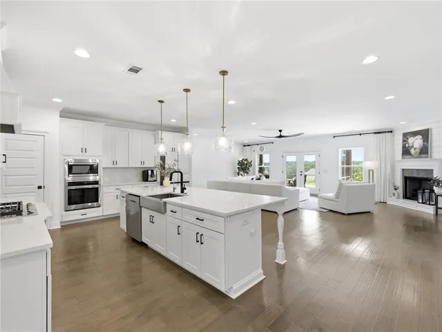 An open concept design seamlessly connects the sleek, modern kitchen to the inviting living area with a fireplace.
