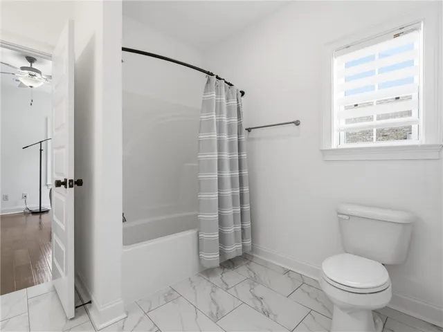 White ceramic tile flooring complements the bright bath area with a clean, functional aesthetic.