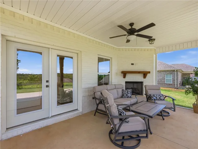 Relax in this inviting covered patio, offering a fireplace and tranquil outdoor living.